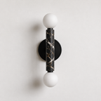 Baton Dual Globe Sconce - Nero Portoro, a black circular backplate, a central black marble cylinder with gold veining, and two matte white spherical shades on either end | IINK Interiors