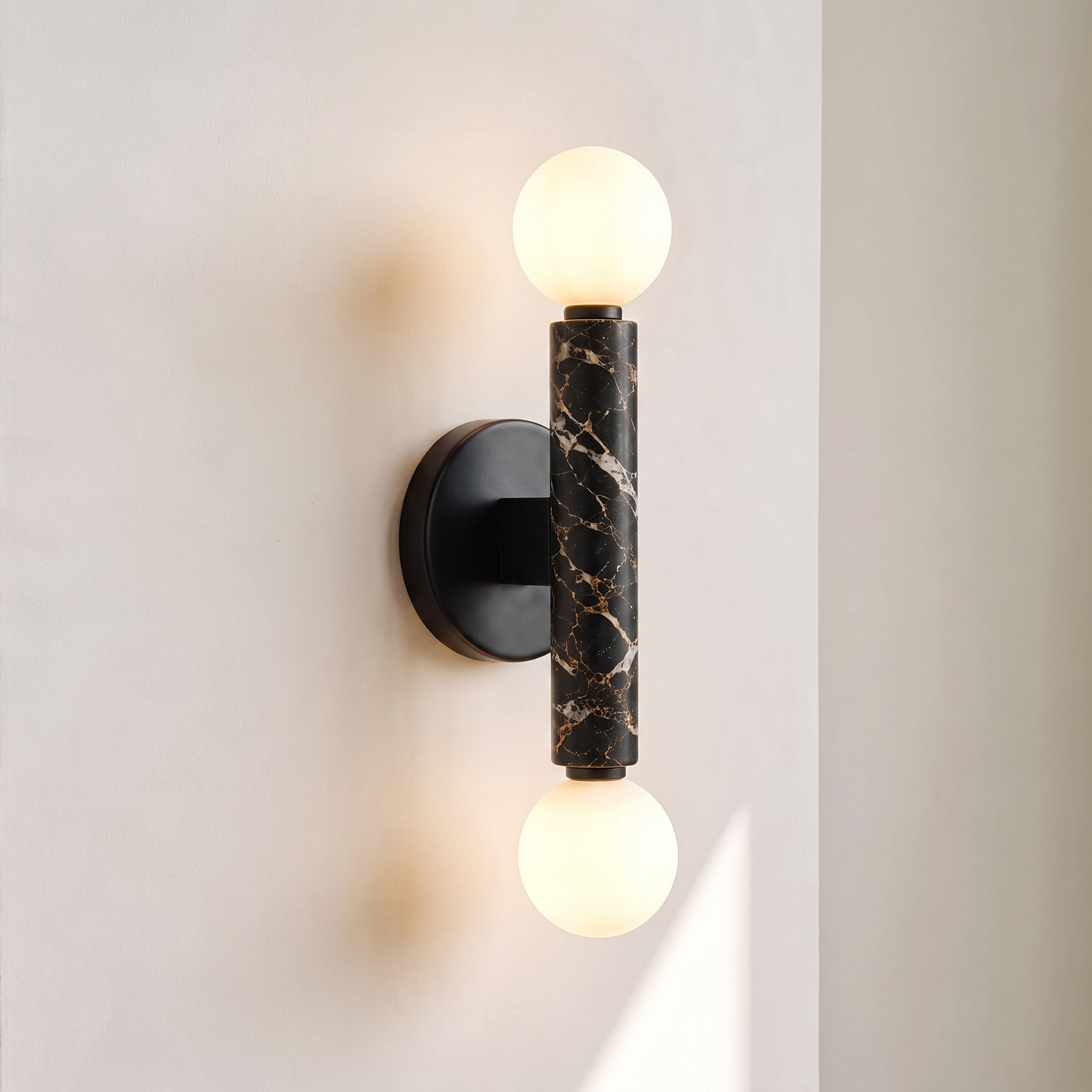 Baton Dual Globe Sconce - Nero Portoro, a black circular backplate, a central black marble cylinder with gold veining, and two matte white spherical shades on either end | IINK Interiors