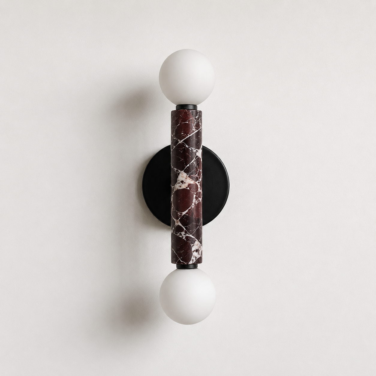 Baton Dual Globe Sconce - Rosso Levanto- two glowing white globe bulbs and a central dark marble column | IINK Interiors