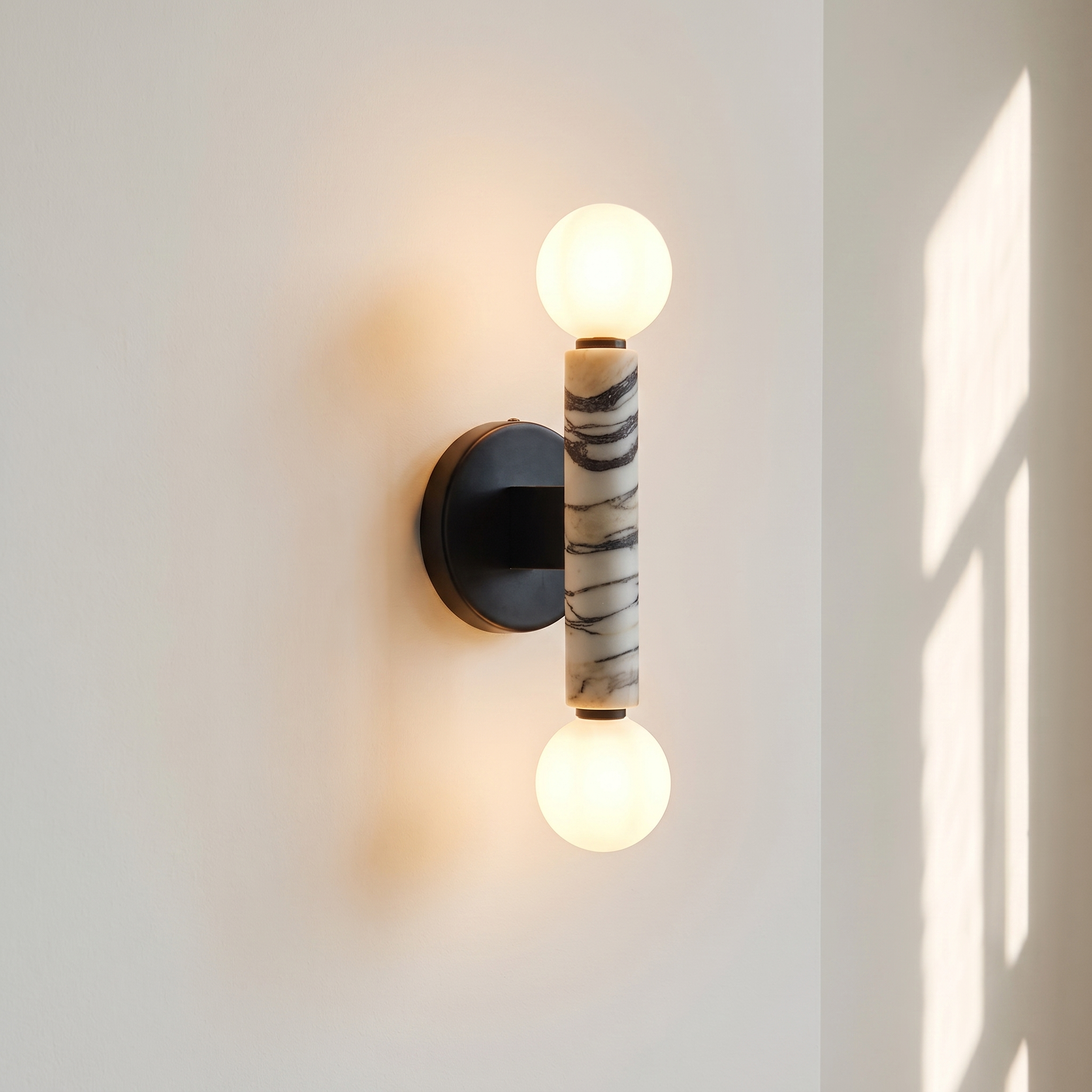Baton Dual Globe Sconce - Calacatta, a black circular backplate, a central marble cylinder with gold veining, and two matte white spherical shades on either end | IINK Interiors