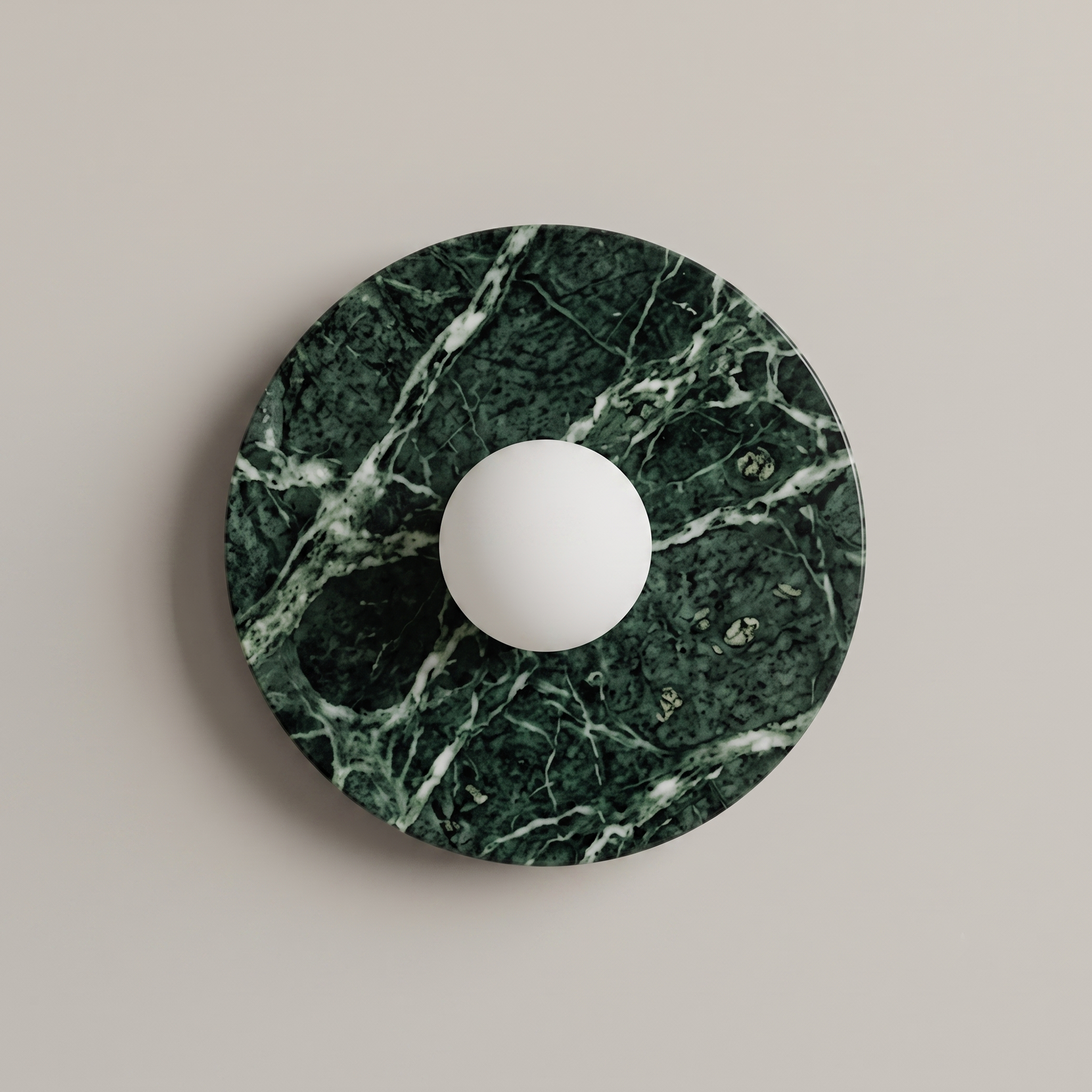 Tondo Planar Sconce, a round wall sconce featuring a dark green marble base with white veining | IINK Interiors