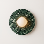 Tondo Planar Sconce, a round wall sconce featuring a dark green marble base with white veining | IINK Interiors