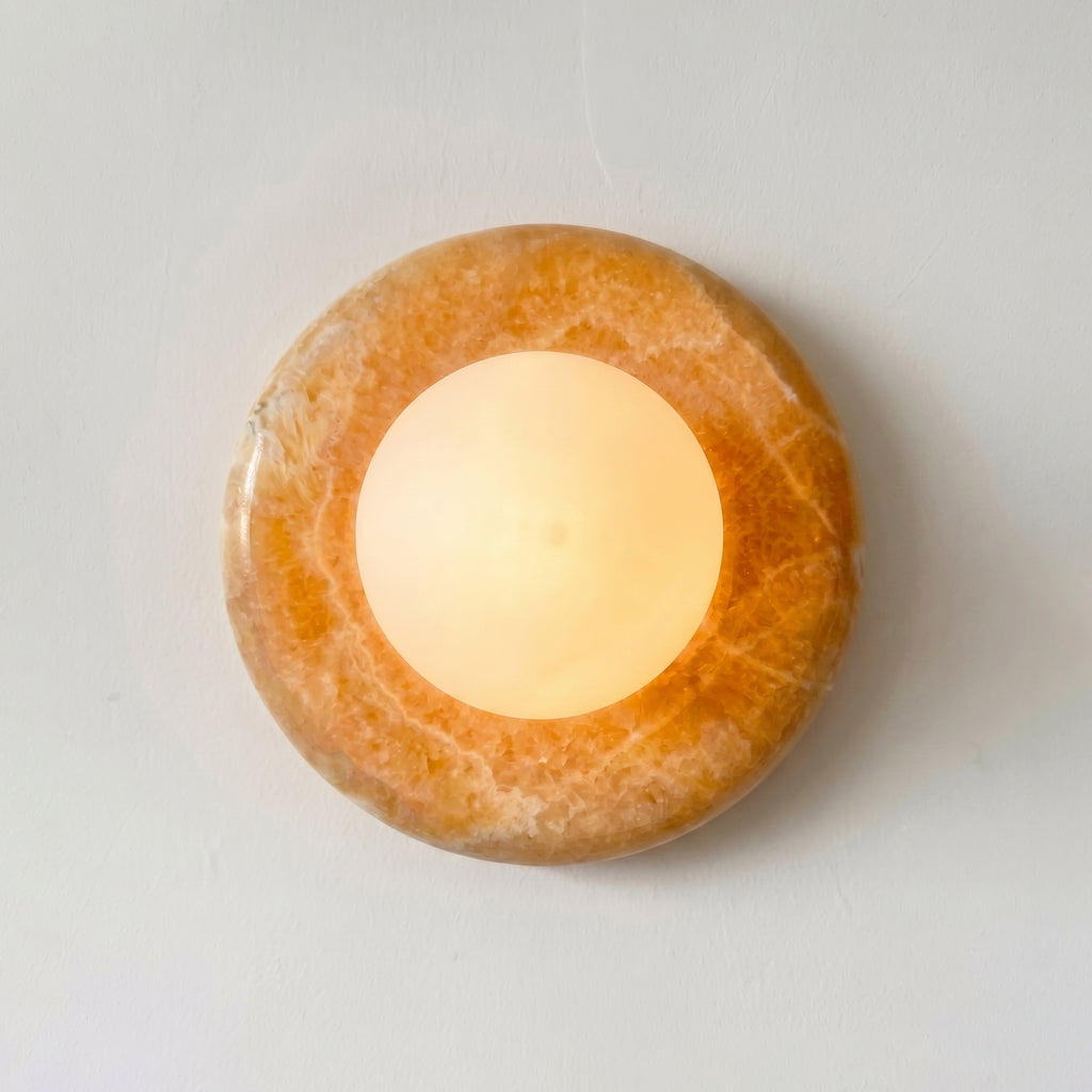 Round stone candle holder with a lit candle on a white background