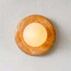 Round stone candle holder with a lit candle on a white background