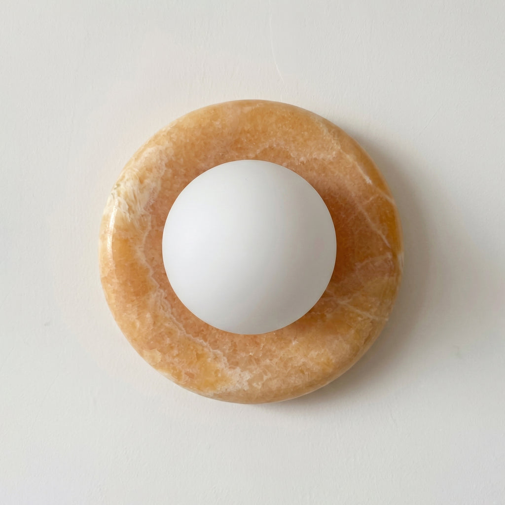 White sphere on a brown circular stone on a light gray background
