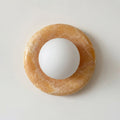 White sphere on a brown circular stone on a light gray background