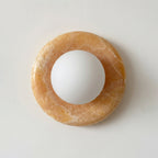 White sphere on a brown circular stone on a light gray background