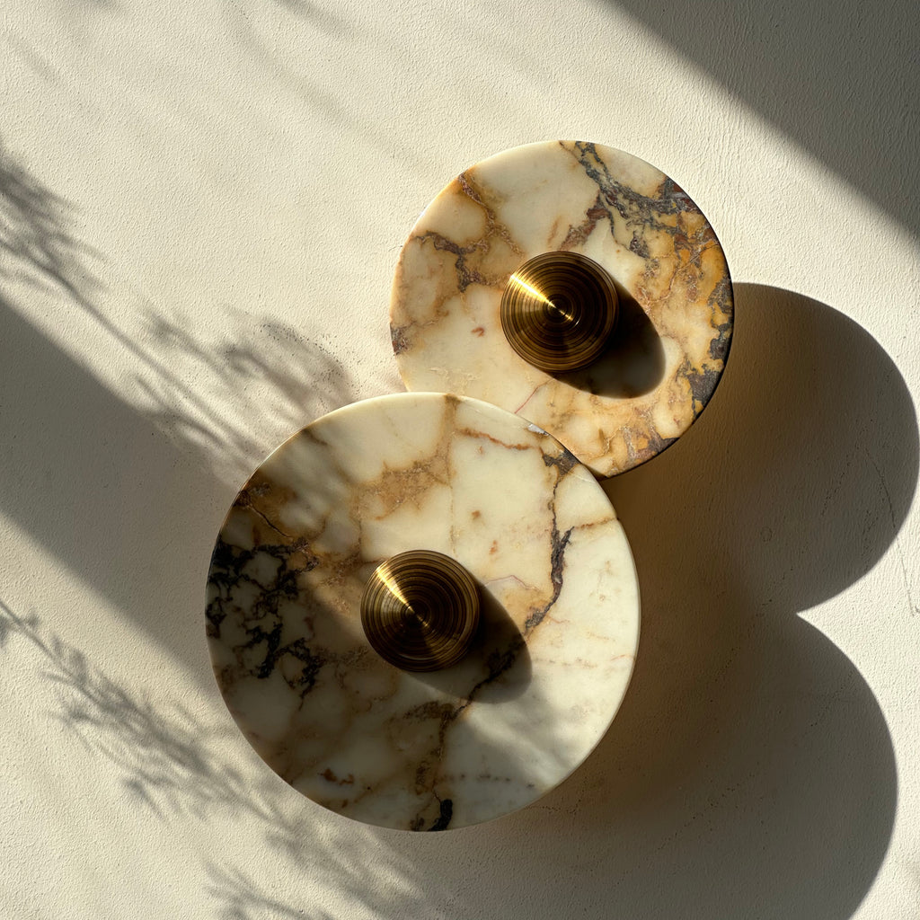 A wall sconce with two Calacatta Viola plates and a brass centre. IINK Interiors