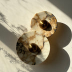 A wall sconce with two Calacatta Viola plates and a brass centre. IINK Interiors